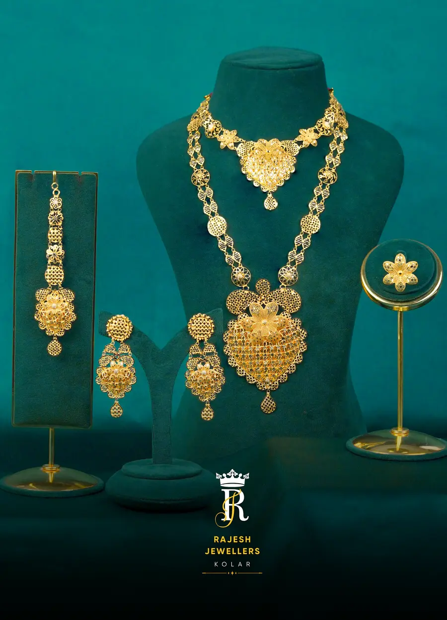 A full bridal suite arranged on teal stands: maang tikka, jhumkas, choker, long haram and a ring.